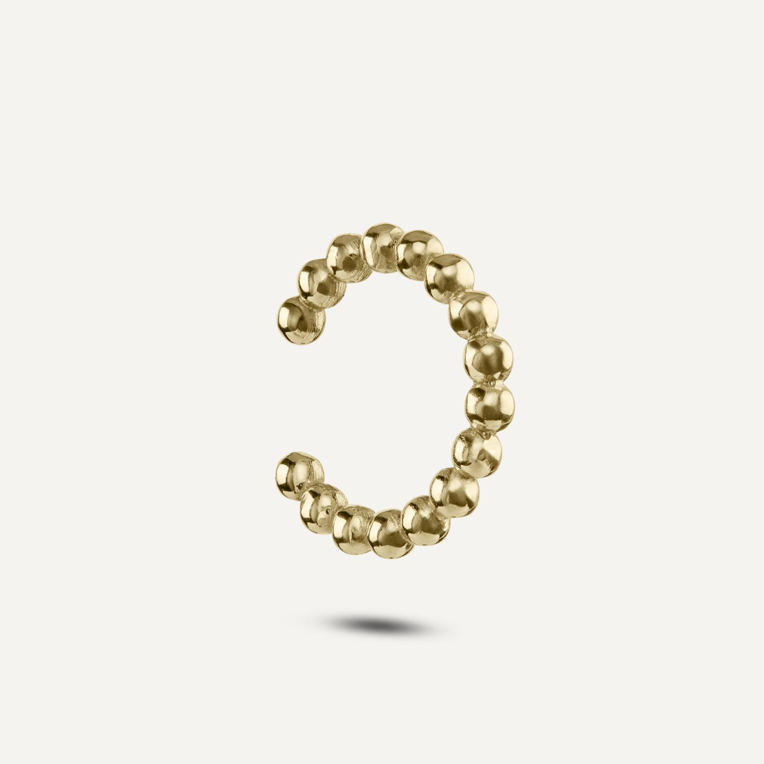 Seitenansicht eines Earcuffs aus kleinen goldenen Kugeln;