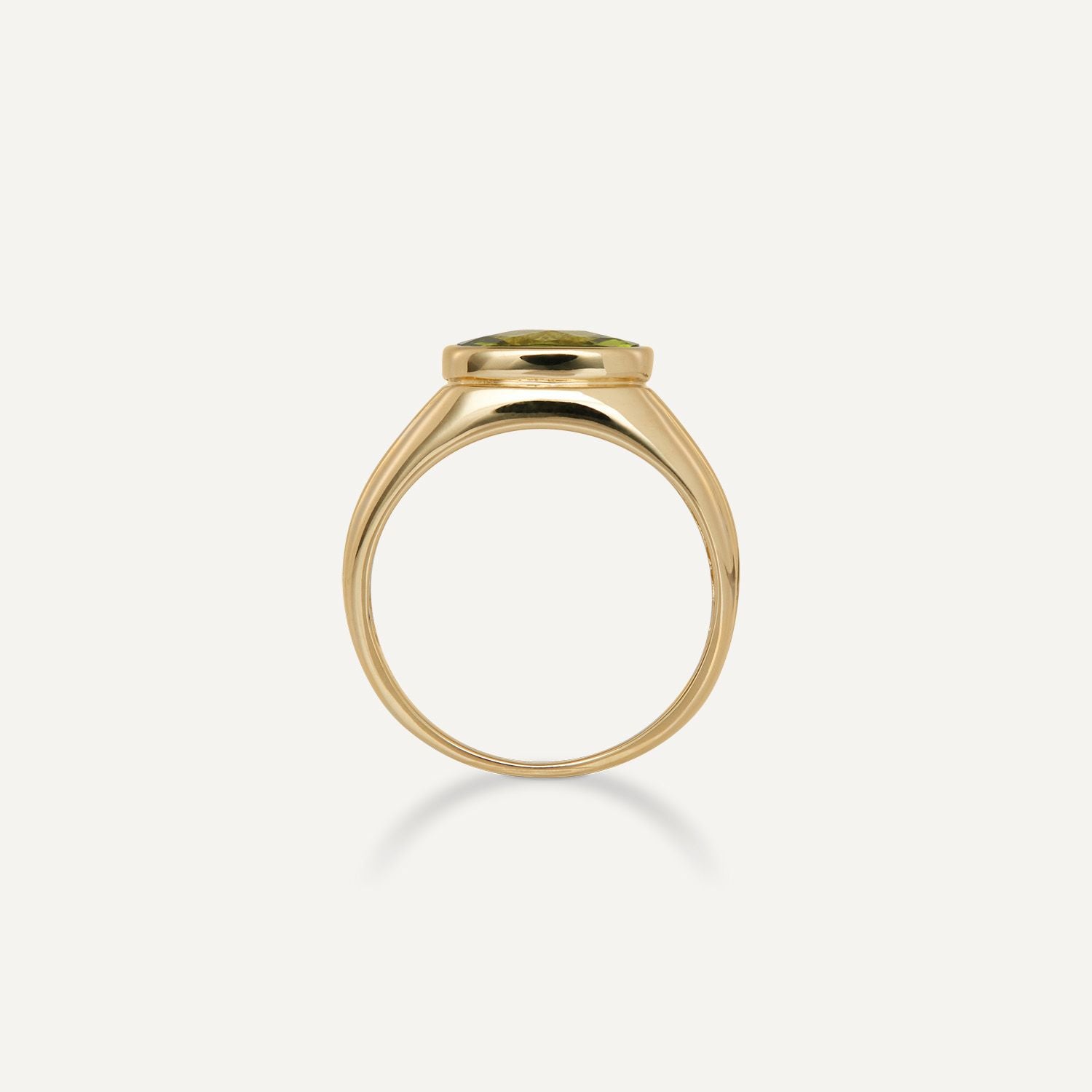 Seitenansicht eines breiten Band-Rings in Gelbgold mit einem eingefassten, viereckigen, grünen Stein;