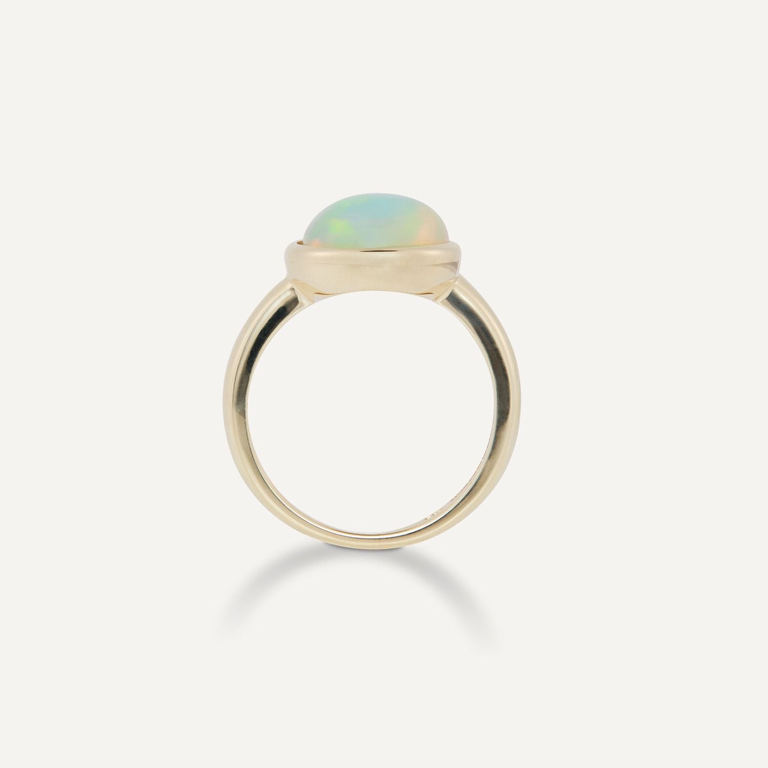 Seitenansicht eines goldenen Band-Rings mit einem großen, ovalen, bläulich schimmernden Opal;
