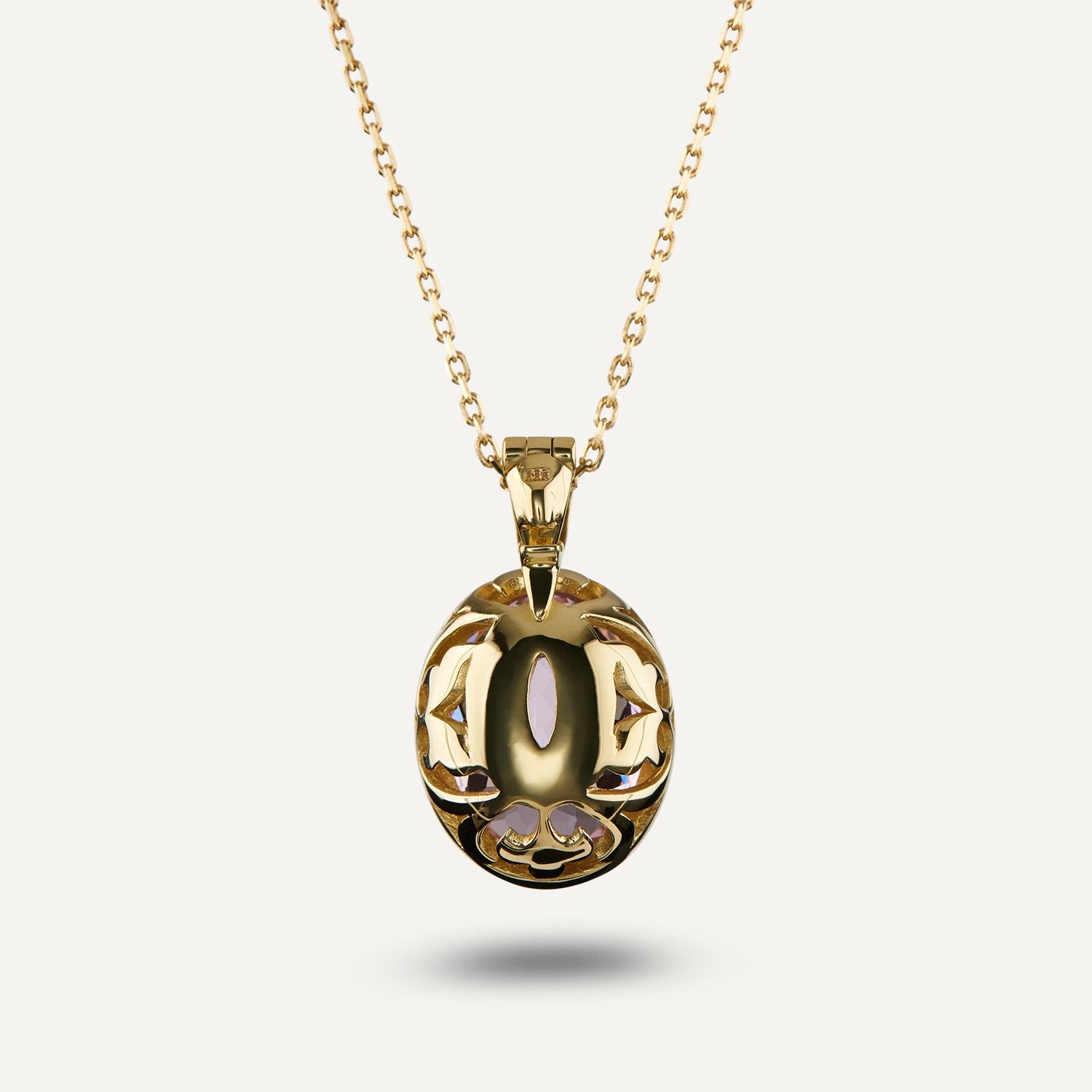 Rückansicht eines goldenen Clip-Anhängers an einer goldenen Gliederkette; der Stein ist auf der Rückseite golden ummantelt und teilweise sichtbar;