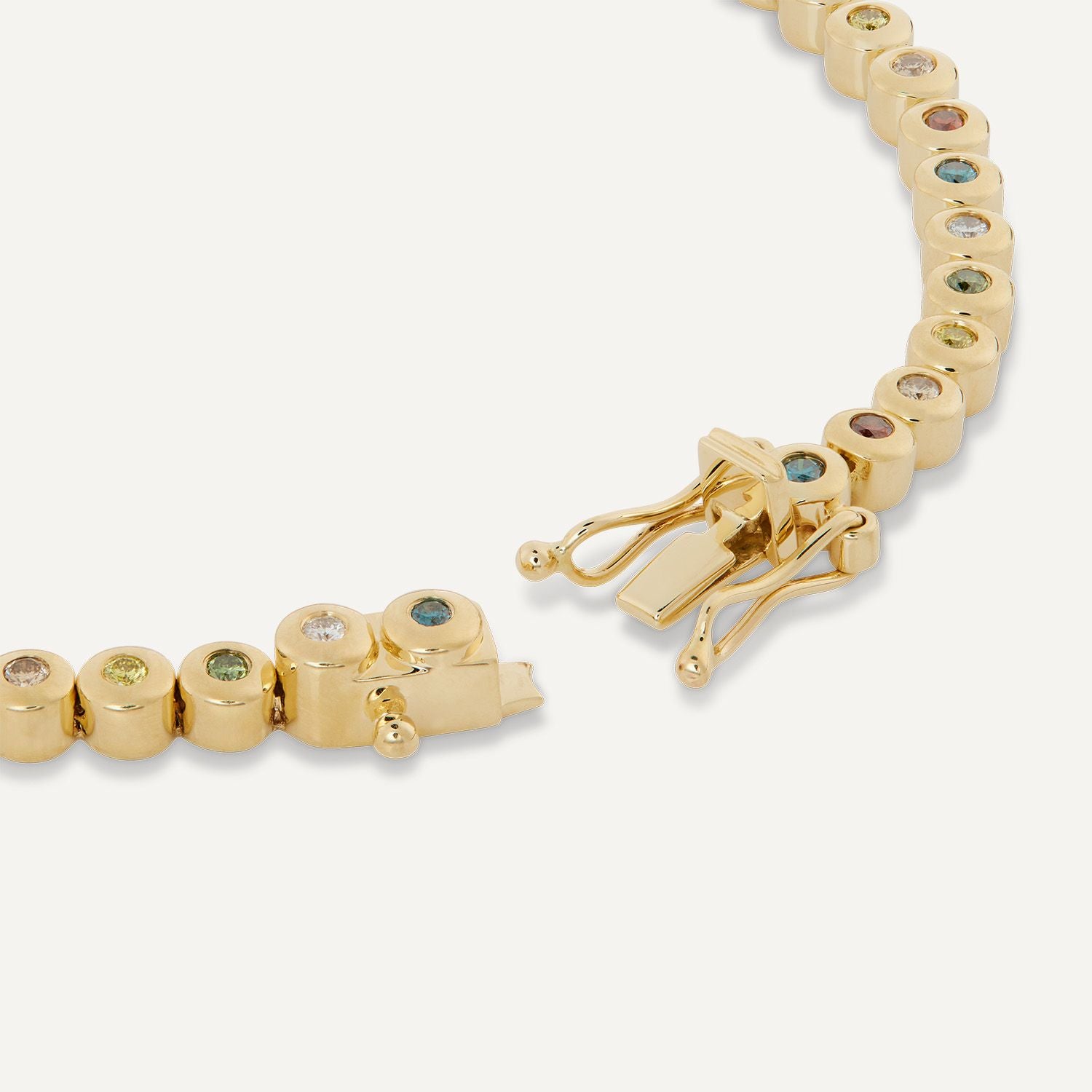 Ausschnitt des goldenen Kastenverschlusses eines Armbands aus Gelbgold mit direkt aneinander gereihten, einzeln eingefassten Brillanten in Gelbgold in den Farben rot, blau, gelb, grün, weiß;