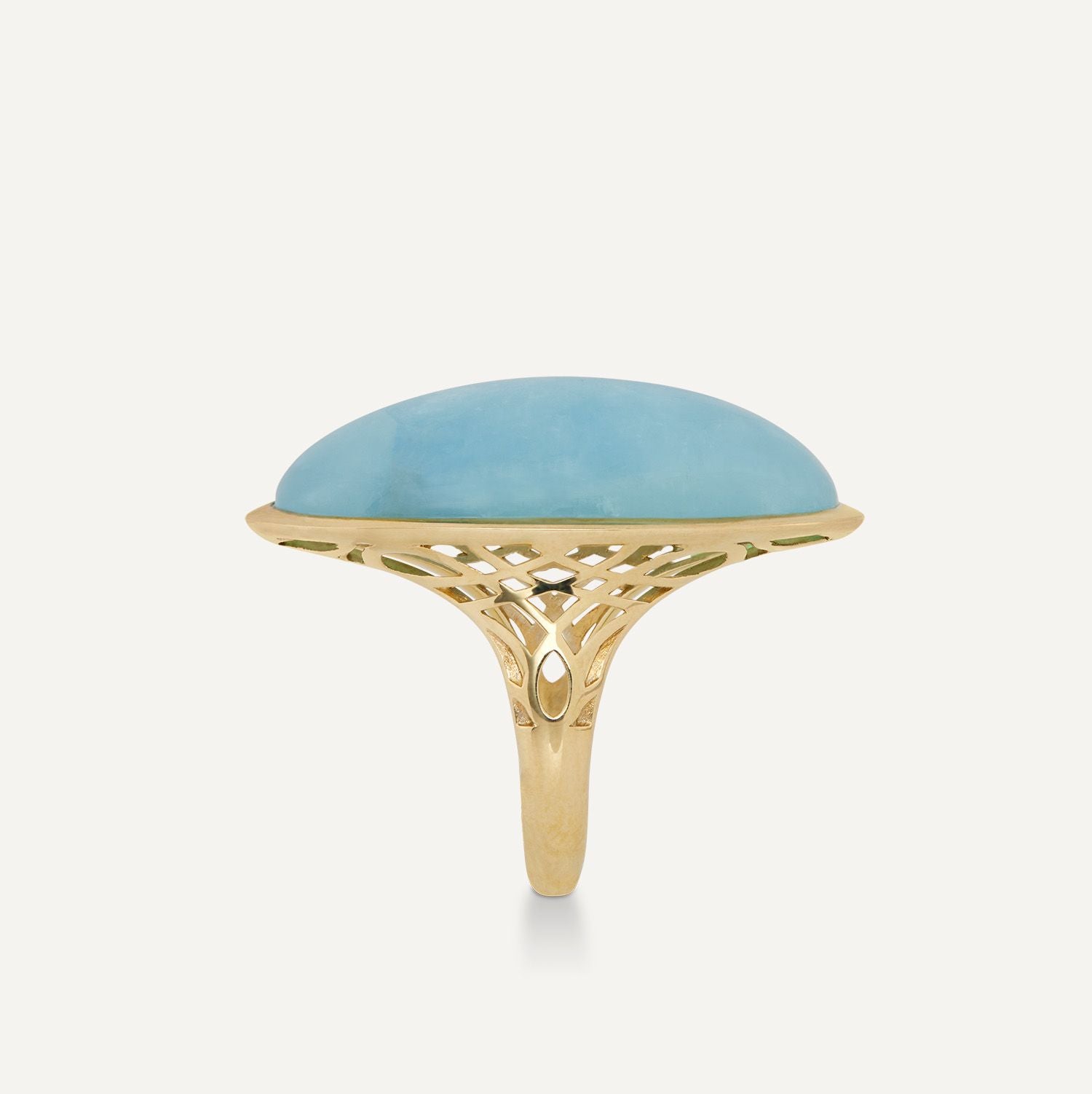 Seitenansicht eines Rings in Gelbgold mit einem großen, in Gelbgold gefassten, hellblauen Stein; der Stein ragt rund hervor;