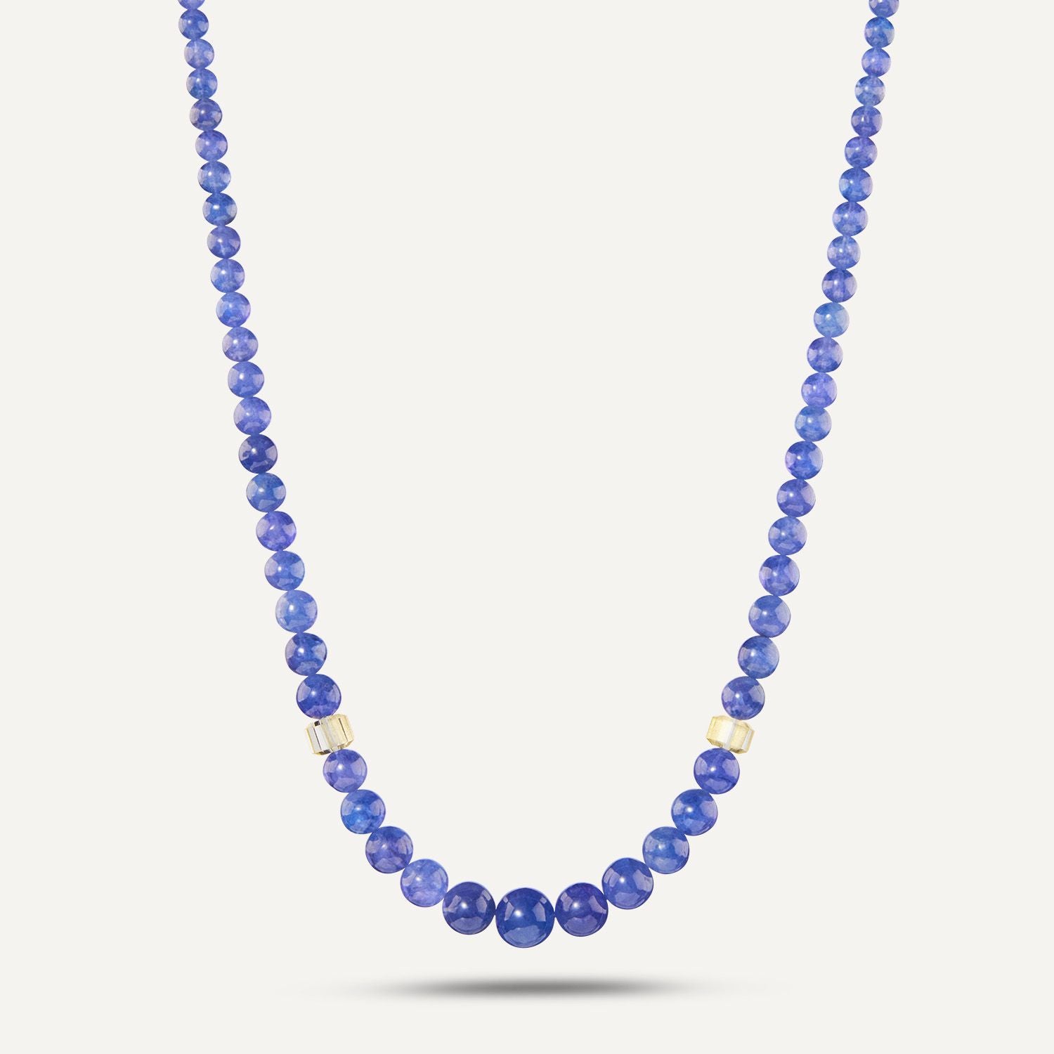 Collier aus direkt aneinander gereihten, blauen, runden Steinen; vom Stein in der Mitte aus jeweils 5 Steine rechts und links ist ein heller Stein eingefügt; die Steine werden zur Mitte hin größer;