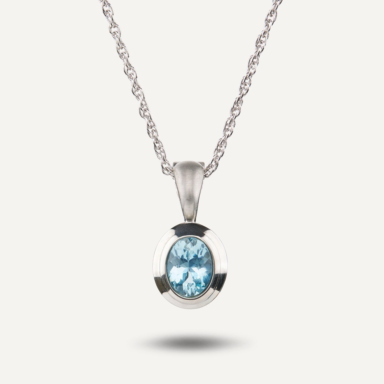 Platin-Anhänger mit einem in Platin gefassten, ovalen, hellblauen Stein an einer Gliederkette aus Platin;