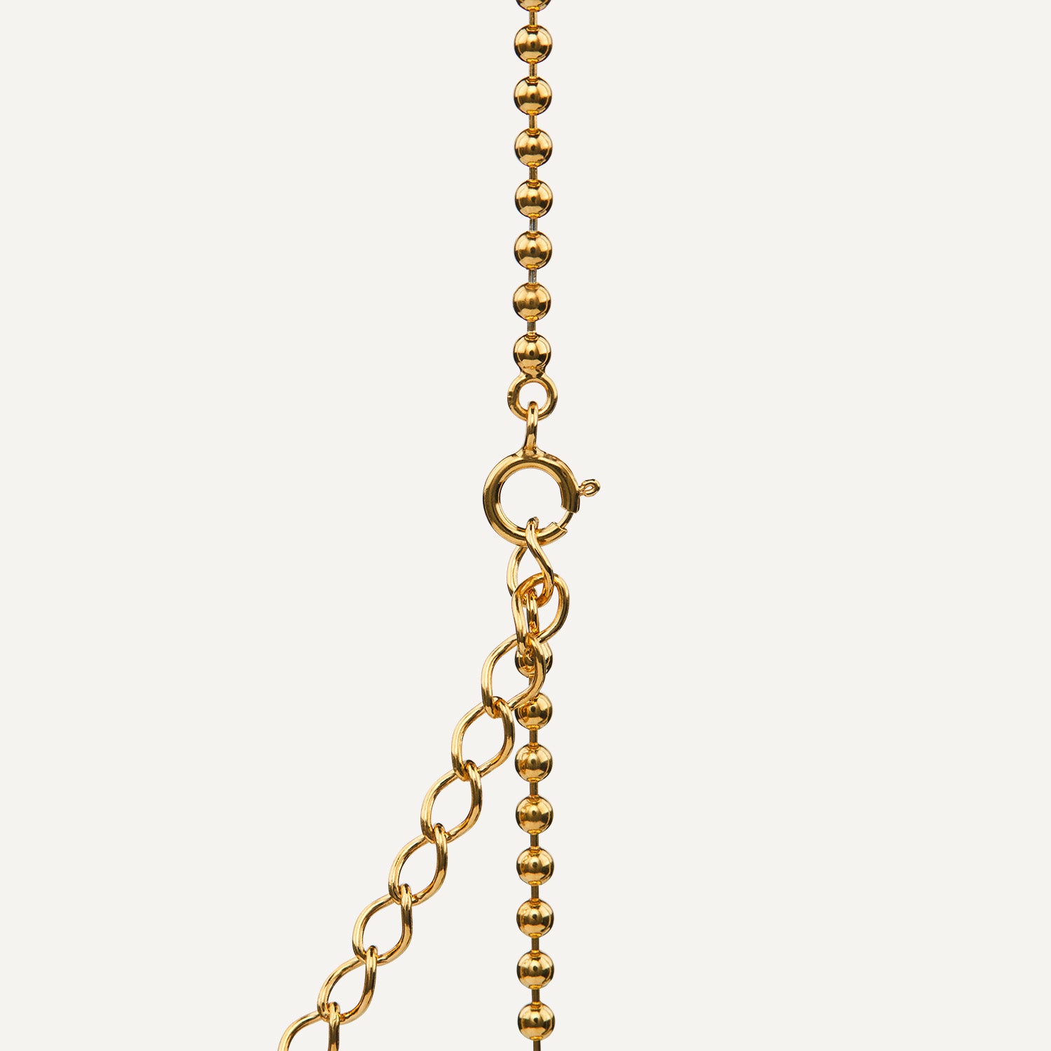 Ausschnitt eines Federverschlusses an einer goldenen Kugelkette;