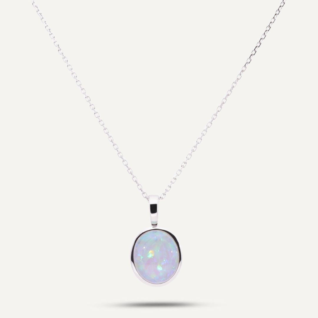 Weißgoldener ovaler Clip-Anhänger mit einem eingefassten bläulich schimmernden Kristallopal an einer weißgoldenen Gliederkette;