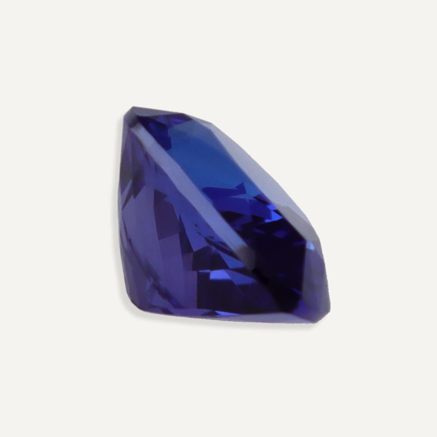 Seitenansicht eines tropfenförmigen, blauen Tansanit Edelsteins;