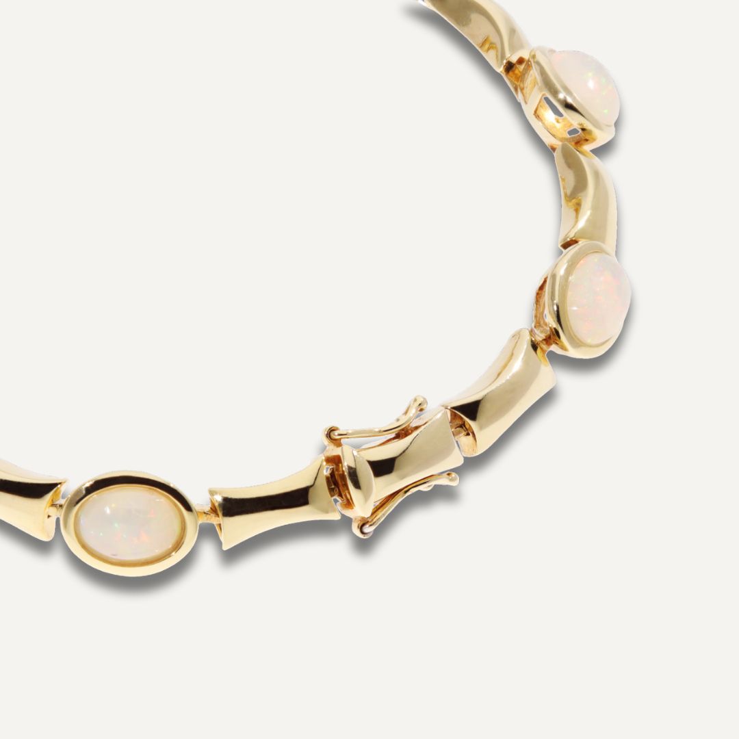 Ausschnitt des Kastenverschlusses eines silbervergoldeten Armbands durchbrochen mit in Gold eingefassten hell schimmernden Kristallopalen;