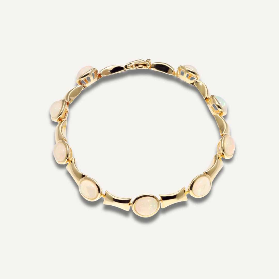 Silbervergoldetes Armband durchbrochen mit neun in Gold eingefassten hell schimmernden Kristallopalen;