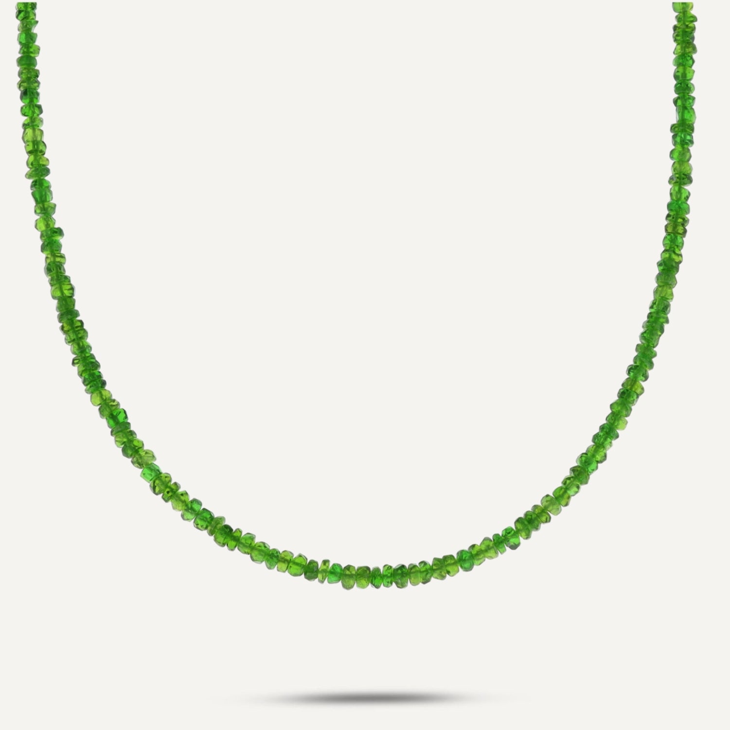 Collier aus direkt aneinander gereihten, kleinen, grünen, unterschiedlich ovalen Steinen;