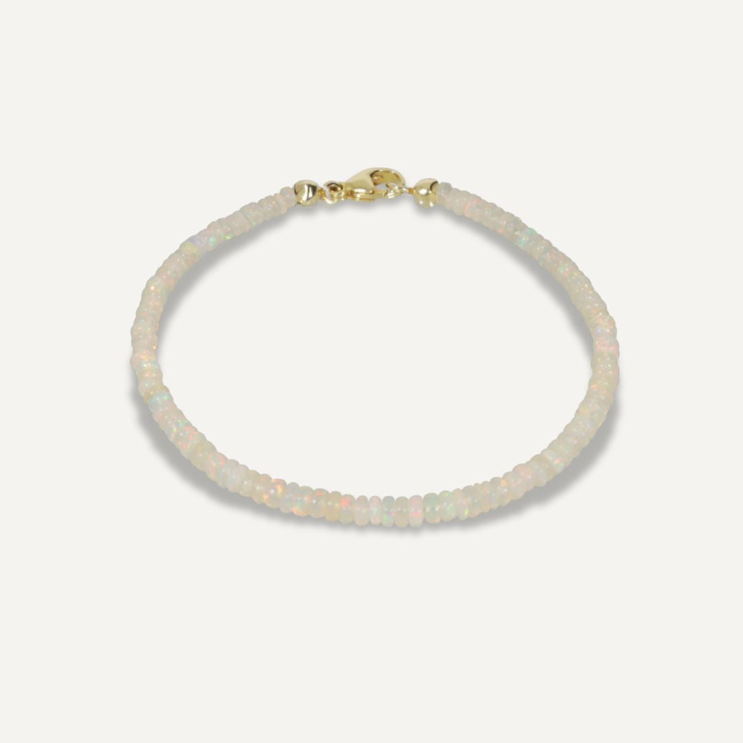 Armband mit direkt aneinandergereihten hell schimmernden Kristallopalen und einem goldenen Karabinerverschluss;