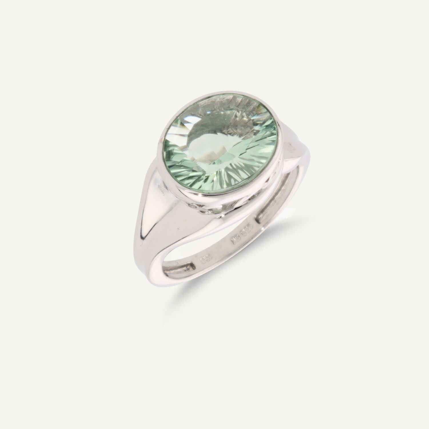 Breiter Band-Ring in Silber mit einem eingefassten, ovalen, hellgrünen Stein;