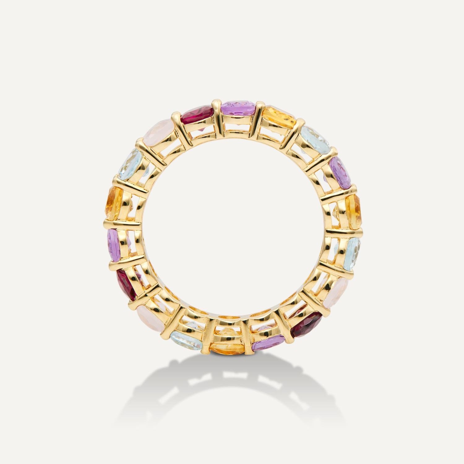 Seitenansicht eines goldenen Rings mit direkt aneinander gereihten runden, bunten Steinen in rot, gelb, weiß, blau, lila;