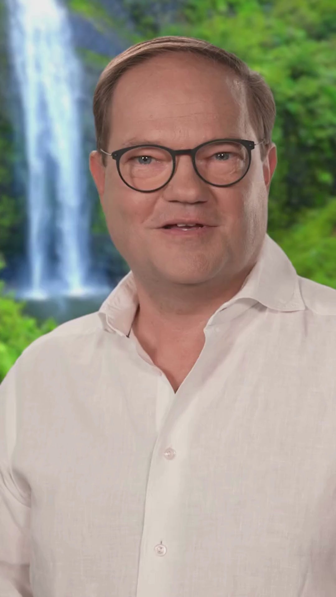 Das Video zeigt René Conradt vor einem Wasserfall und Bäumen;