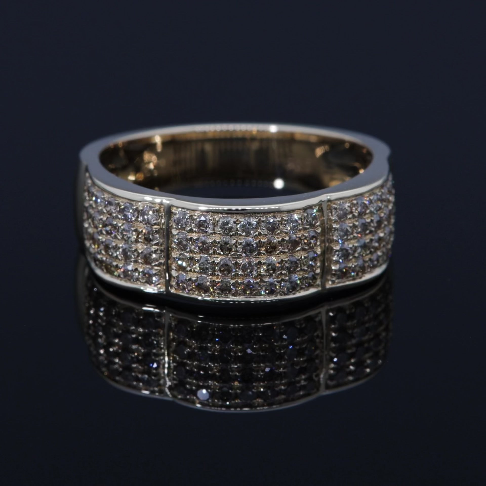 Das Video zeigt einen goldenern breiten Ring mit vier Reihen kleiner weißer Brillanten; die Reihen sind durchbrochen;