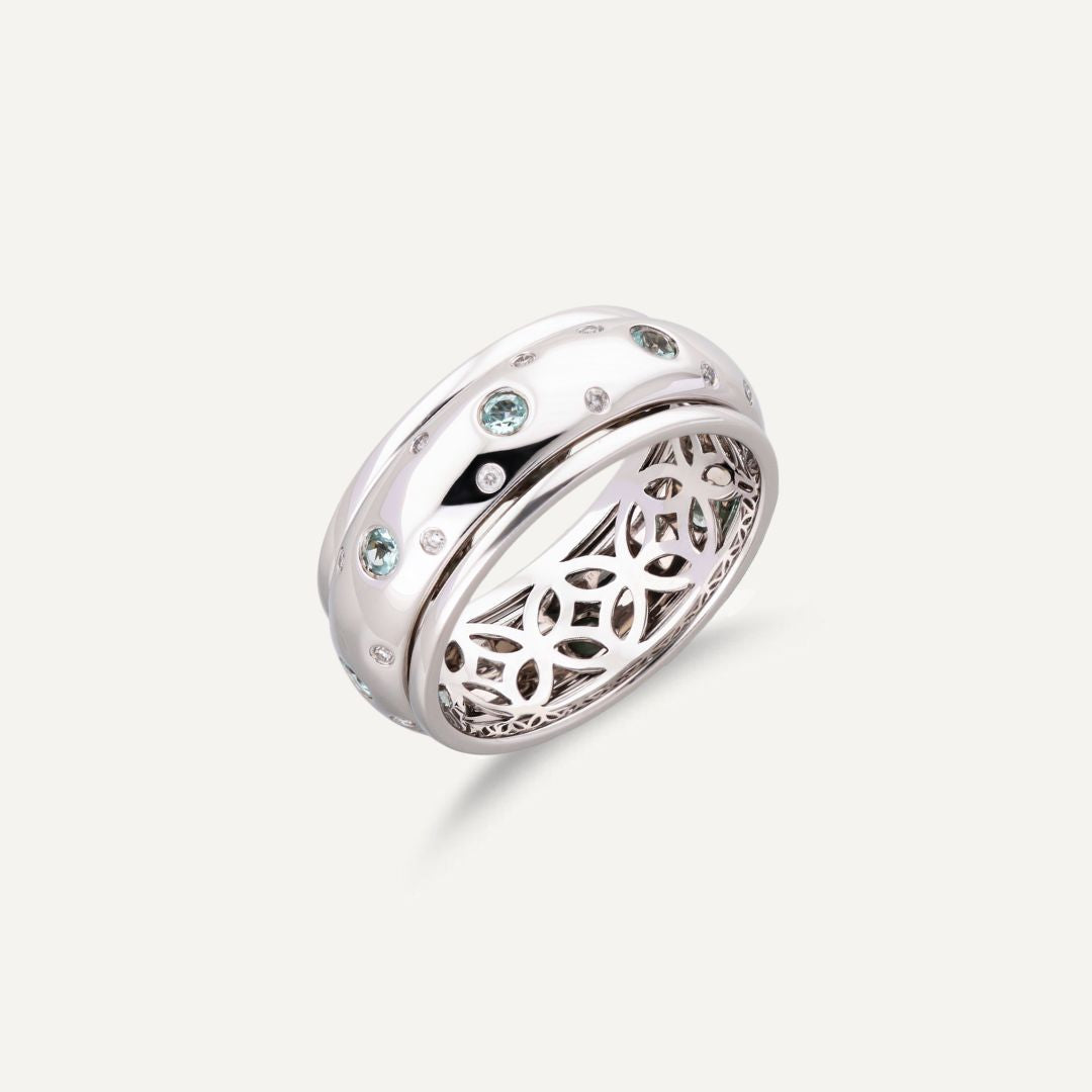 Breiter Band-Ring in Weißgold mit kleinen vereinzelten Brillanten außen und größeren weißen Steinen in der Mitte; innen ist der Ring nicht glatt sondern offen mit runden Ornamenten;