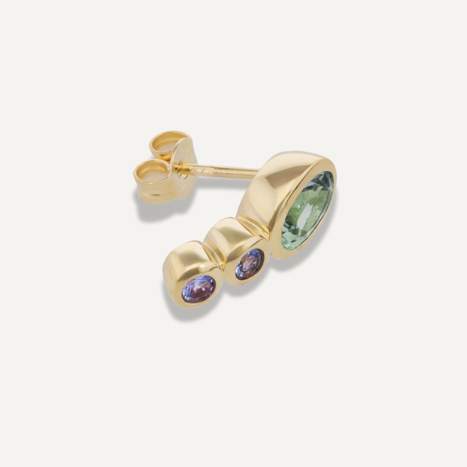 Seitenansicht eines Ohrsteckers in Gelbgold mit einem in Gelbgold gefassten größeren, ovalen grün-blauen Stein und darunter untereinander zwei blau-violette in Gelbgold gefasste, kleinere, runde Steine;
